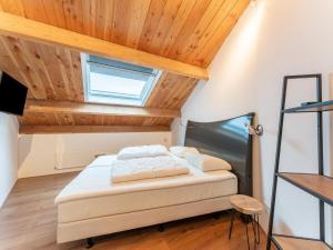 Ce lit se trouve dans un dortoir doté d'un plafond en bois. dans l'établissement Modern holiday home in Goirle with sauna, à Goirle