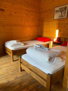 um quarto com duas camas num chalé de madeira em Bungalovi Malina em Novi Sad