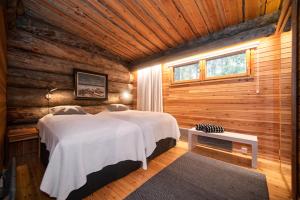 - une chambre avec 2 lits dans une cabane en rondins dans l'établissement Keloruka 15 luxury lodge, 5 ensuite bedrooms, 250 m2, jacuzzi, 2 x ski pass, à Ruka