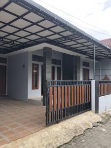 una casa con un porche con una valla en Richandy House - 3 BR Full AC & Hot Water, en Kejayan