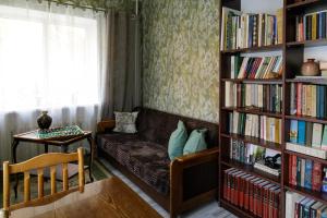 uma sala de estar com um sofá e prateleiras de livros cheias de livros em Lat4Rest em Prienai
