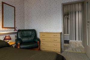 um quarto com uma cadeira e uma cómoda com um espelho em Lat4Rest em Prienai