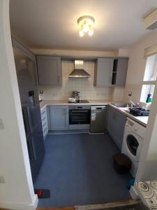 a small kitchen with a sink and a stove at 2 bedroom flat in SW London in Sutton