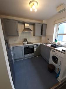 a kitchen with a washing machine and a washer at 2 bedroom flat in SW London in Sutton