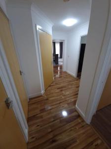 an empty hallway with a wooden floor in a house at 2 bedroom flat in SW London in Sutton