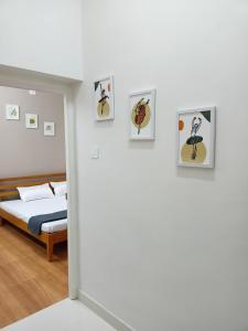 sypialnia z łóżkiem i obrazami na ścianie w obiekcie Meadows Homestay w mieście Maduraj