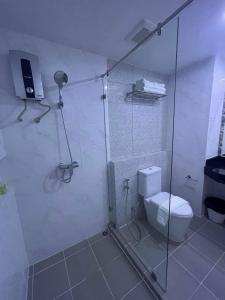 a bathroom with a glass shower with a toilet at Christella Hotel Laemchabang in Si Racha