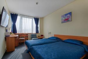 a hotel room with two beds and a desk at Hemus Hotel Sofia in Sofia