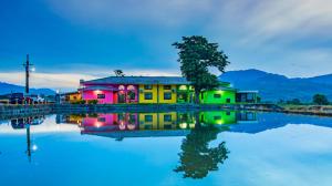 una casa colorida junto a un cuerpo de agua en 小葉園民宿Little Ya B&B en Ruilong