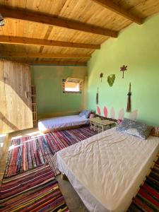 a bedroom with two beds and a green wall at Hidden place in ‘Izbat Ţanāţī