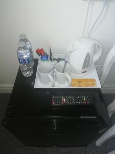 una mesa con una bandeja con tazas y una botella de agua en The Antelope Hotel, en Merthyr Tydfil