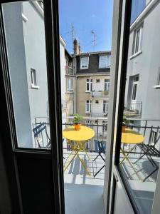a view of a balcony with a yellow table and chairs at Appart Cosy 55m2 avec Balcon proche Gare 2P in Metz
