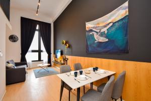 Sunway Grid Loft Suite by Nest Home【Olympic Size Pool】 في Kampong Pendas: غرفة معيشة مع طاولة و لوحة على الحائط