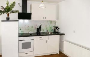 a kitchen with white cabinets and a sink at 1 Bedroom Nice Apartment In Passow Ot Charlottenho in Zahren