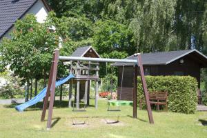 un parque infantil en un patio con tobogán en Trassenheide, Ferienidyll Neubauer, en Ostseebad Karlshagen