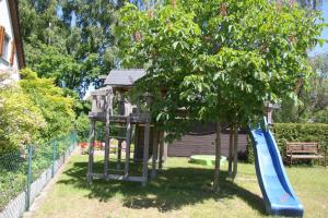 un parque infantil con un tobogán en un árbol en Trassenheide, Ferienidyll Neubauer, en Ostseebad Karlshagen