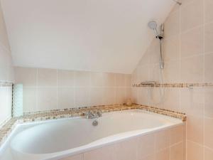 a white bath tub in a tiled bathroom at Am Bruadar in Dalmally