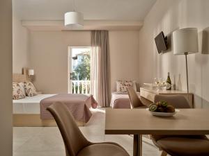 a bedroom with two beds and a table and chairs at Katerina Studios in Tsilivi