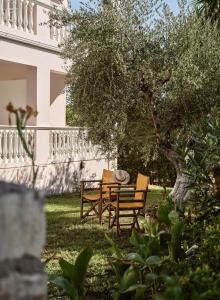 un tavolo e sedie sotto un albero in un cortile di Katerina Studios a Tsilivi