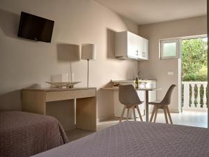 um quarto com uma cama e uma cozinha com uma mesa e cadeiras em Katerina Studios em Tsilivi