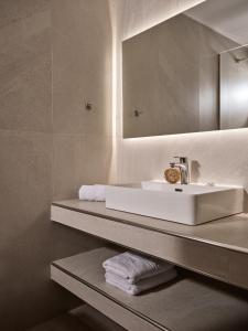 a bathroom with a sink and a mirror and towels at Katerina Studios in Tsilivi