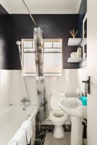 a bathroom with a toilet and a sink at Sunset View Apartment with Free Secure Parking in Central Location in Centurion