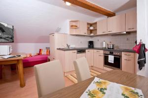 a kitchen with a table and a dining room at Appartements Wasserfälle in Mayrhofen
