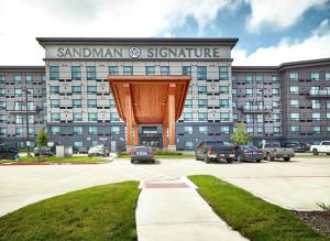 普莱诺Sandman Signature Plano-Frisco Hotel的一座大建筑,上面有读写Santa ana签名的标志