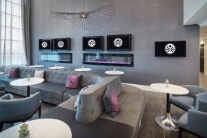 普莱诺Sandman Signature Plano-Frisco Hotel的一间配有沙发和桌子的餐厅