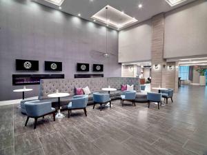 普莱诺Sandman Signature Plano-Frisco Hotel的配有沙发和桌椅的大厅