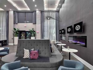 a lobby with a couch and tables and chairs at Sandman Signature Plano-Frisco Hotel in Plano