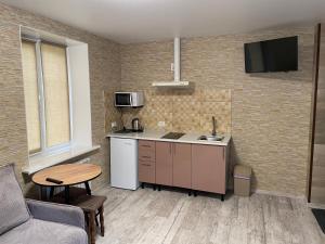 eine Küche mit einem Sofa und einem Tisch in einem Zimmer in der Unterkunft Смарт-квартира біля озера in Winnyzja