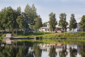a boat on a lake with houses and trees at Best Western Hotel Botnia in Umeå