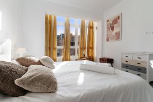 a white bed with two stuffed animals on it at Casa Manuela in Las Palmas de Gran Canaria