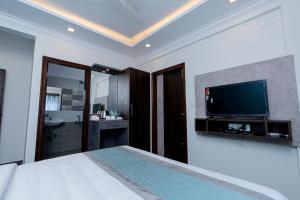 a bedroom with a bed and a flat screen tv at VALUE INN in Bangalore
