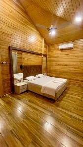 1 dormitorio con 1 cama en una habitación de madera en The Arowana Divine, en Nanded
