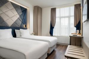イスタンブールにあるアダマル ホテルのベッド2台と窓が備わるホテルルームです。