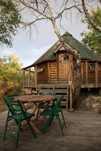 una mesa de picnic y sillas frente a una cabaña en Le Bois Davy en Le Thoureil