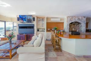 uma cozinha e sala de estar com uma mesa e uma lareira em Whale Waters Self Catering Gansbaai em De Kelders