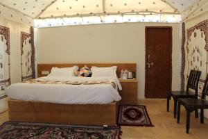 a bedroom with a large bed and a table at Iceland Luxury Desert Camp in Sām