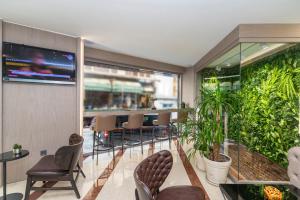 a lobby with chairs and a large green wall at Aprilis Hotel - Special Category in Istanbul
