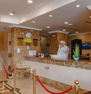 a man talking on a cell phone at a bar at فندق البيوتات in Jeddah