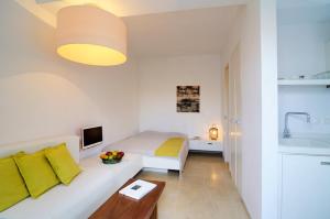 Sala de estar blanca con cama y sofá en Orloff Resort, en Spetses