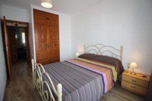エンプリアブラバにあるBasic Comfort Apartment Port Segre 0169のベッドルーム1室(ストライプ毛布とドア付)