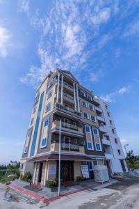 a tall apartment building with a blue sky at VALUE INN in Turuvekere