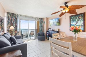 a dining room and living room with a table and a couch at Atlantica Towers Condo w Balcony by Hosteeva in Myrtle Beach