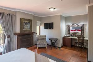 a hotel room with a bed and a desk and chair at Greenway Woods Accommodation in White River