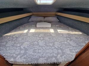 een bed aan de achterkant van een kleine kamer bij *NEW* GORGEOUS BOAT STAY WITH VIEWS! in Brixham
