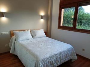 - une chambre avec un grand lit et une fenêtre dans l'établissement Bandos, refugio natural, à Cines