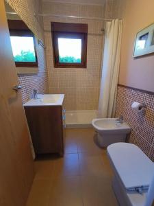 La salle de bains est pourvue d'un lavabo, de toilettes et d'une fenêtre. dans l'établissement Bandos, refugio natural, à Cines